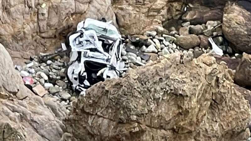 The car wreck at the base of the 250ft cliff (Image: Uncredited/AP/REX/Shutterstock)