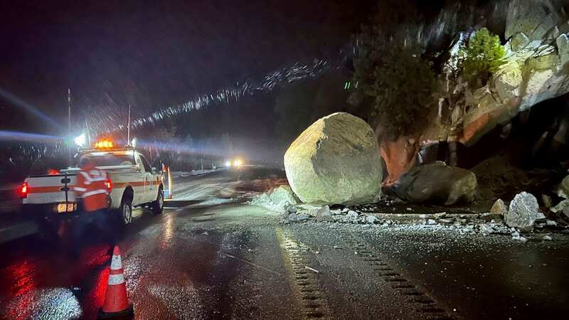 Transportation crews check large boulders that fell onto a highway during a storm (Image: Uncredited/AP/REX/Shutterstock)