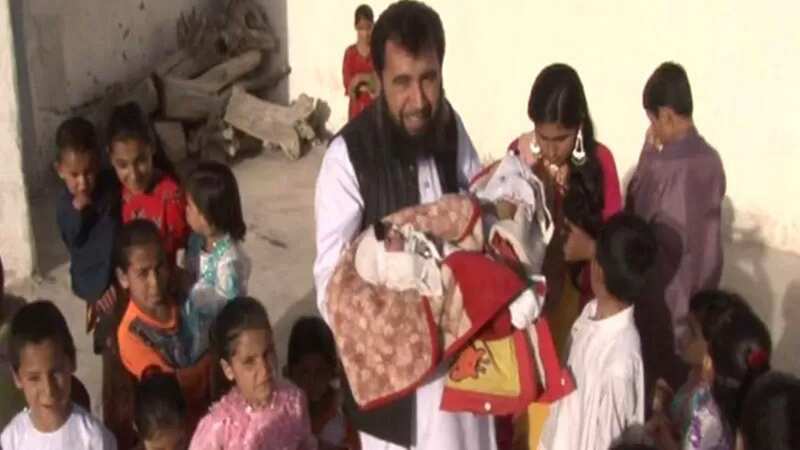 Sardar Jan Mohammad Khan Khilji holds his new baby while thronged by his enormous brood (Image: Jam Press)