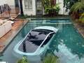 Tesla crashes through wall and into swimming pool as boy, 4, has to be rescued