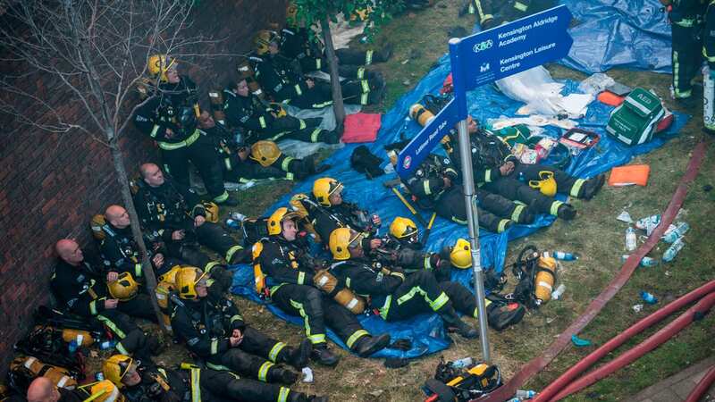 Firefighters rest at the scene of a huge fire at Grenfell tower block (Image: Guilhem Baker/LNP)