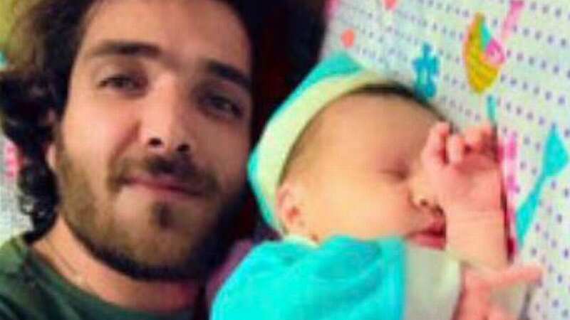 Condemned Hassan Firouzi lays beside his baby (Image: CEN)