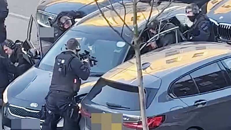Armed police can be seen swarming a car to make an arrest following a drive-by shooting at a memorial service