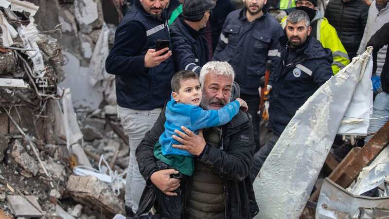 His uncle carries Yigit Cakmak, 8-year-old survivor at the site of a collapsed building (Image: Getty Images)