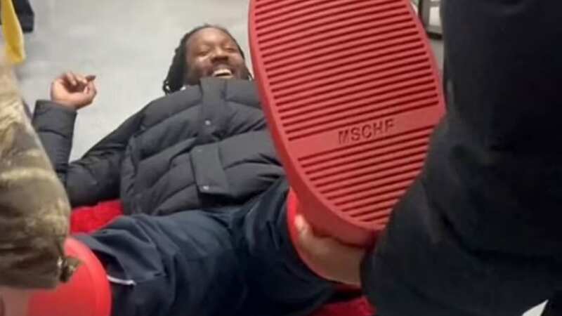 Panicked man desperately tries to remove $350 red shoes after they get stuck