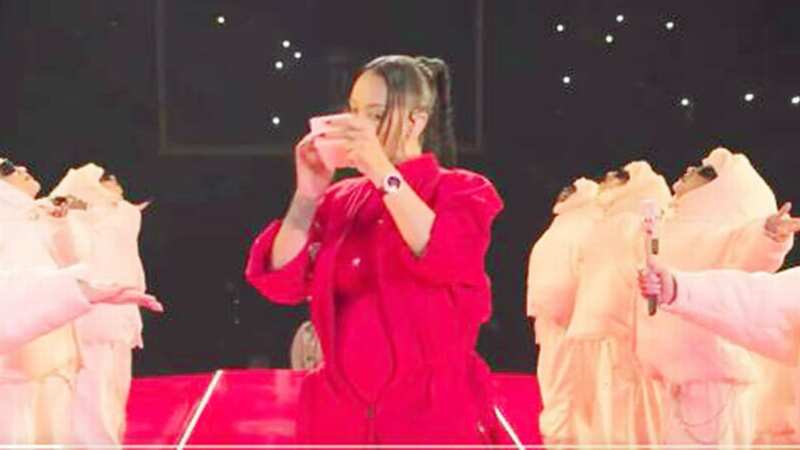 Rihanna touching up her make up during her performance (Image: NFL/Youtube)