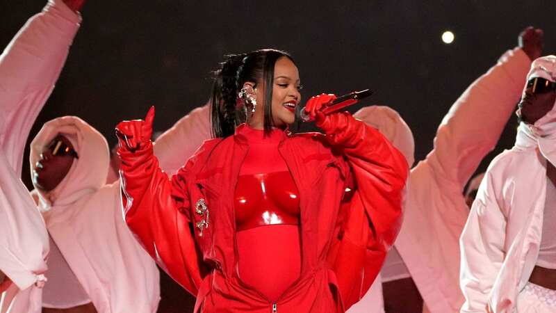 Rihanna looked stunning, donning a bold red lip and flawless looking skin at the Super Bowl (Image: Getty)