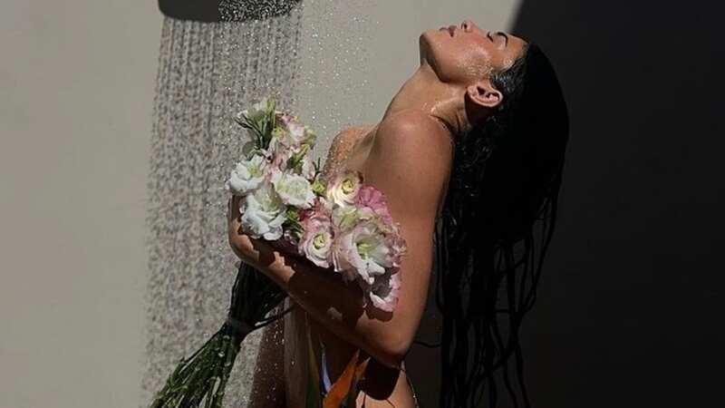 Kylie Jenner poses totally nude in the shower covering modesty with some flowers