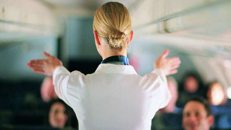 A flight attendant giving a safety talk on a plane (Image: Getty)