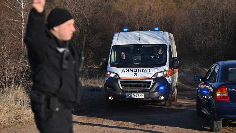 A security official gestures as an ambulance moves on the outskirts of the village of Lokorsko, some 12 miles north-east of Sofia (Image: AFP via Getty Images)