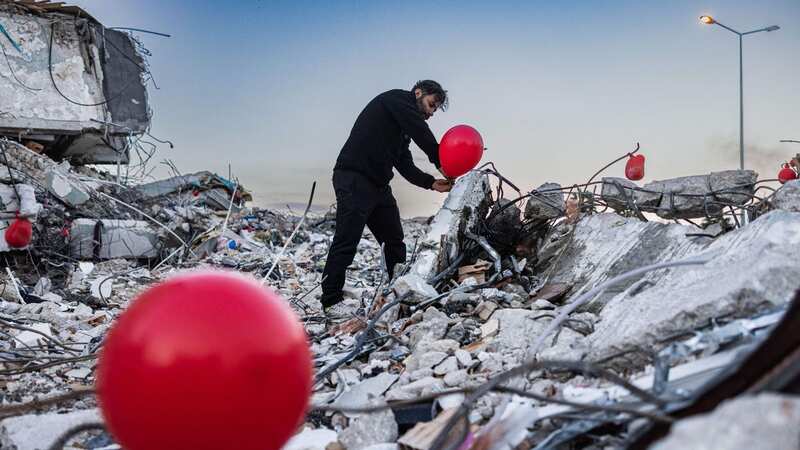 A man lies a tribute in the wreckage of the quake that killed 50,000 (Image: AFP via Getty Images)