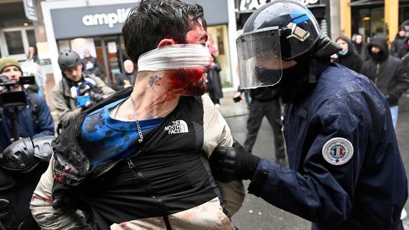 Riot officers detain a man during a rally to protest forced changes to the fishing industry (Image: AFP via Getty Images)