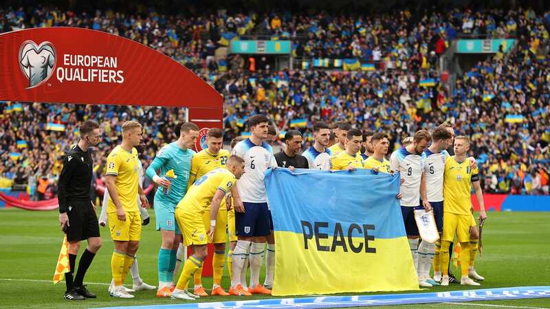 Players from both sides posed for a photograph with a Ukraine flag with the word Peace on
