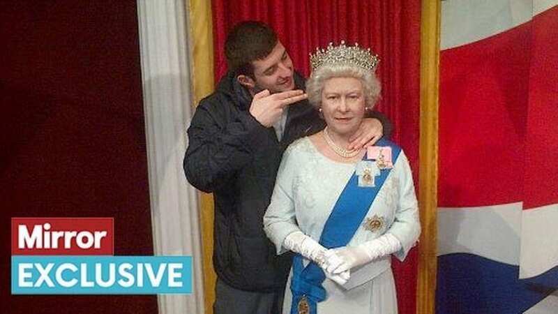 Thomas Cashman making a mock shooting gesture at a waxwork of the late Queen