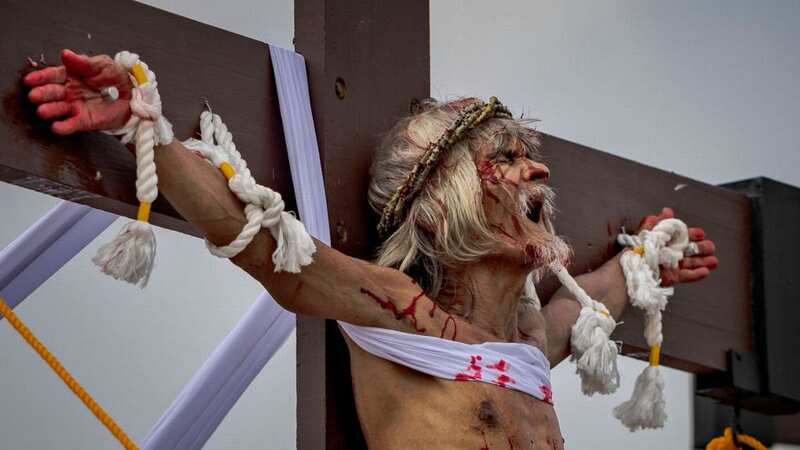 A man cries out in agony after being nailed to a cross in a Good Friday ritual in the Philippines (Image: Getty Images)