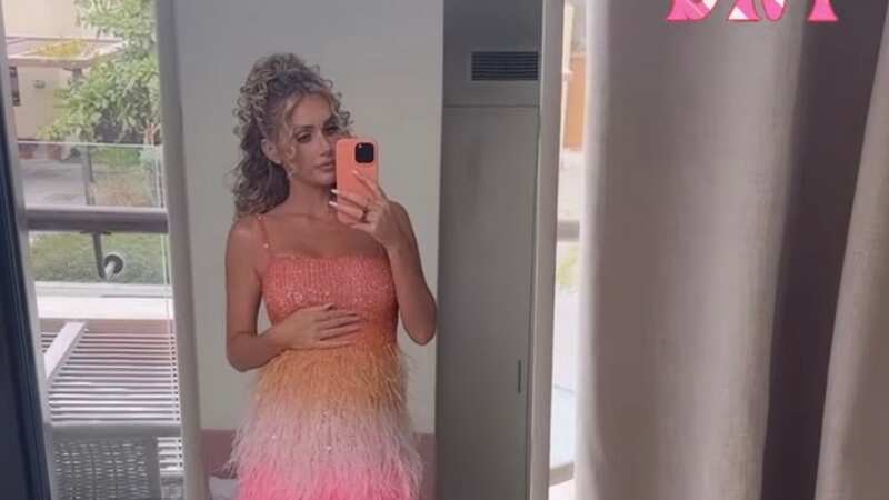 Pregnant Laura Anderson is seen cradling her bump in a colourful tassel dress (Image: Instagram)