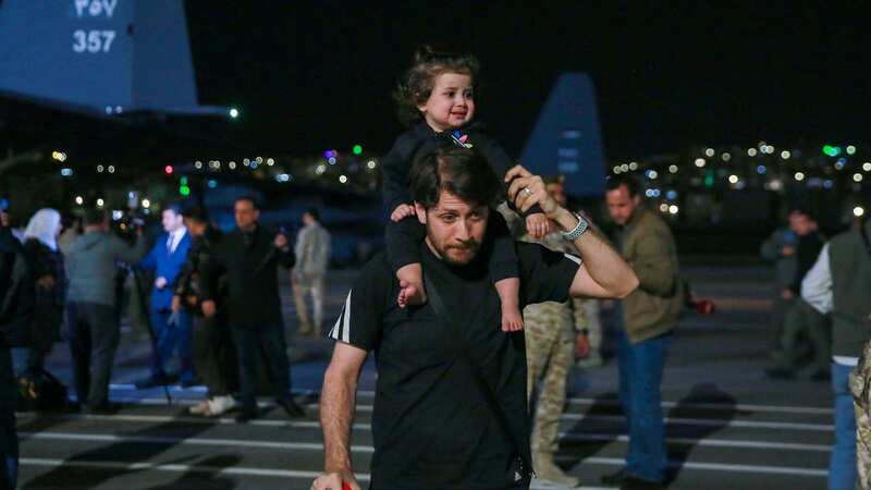 Adults and children at a military airport in Amman after being evacuated from Sudan (Image: AFP via Getty Images)