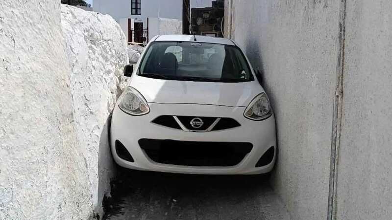 The unidentified tourist got their Nissan Micra hire car trapped between two walls in Santorini, Greece (Image: Jam Press)