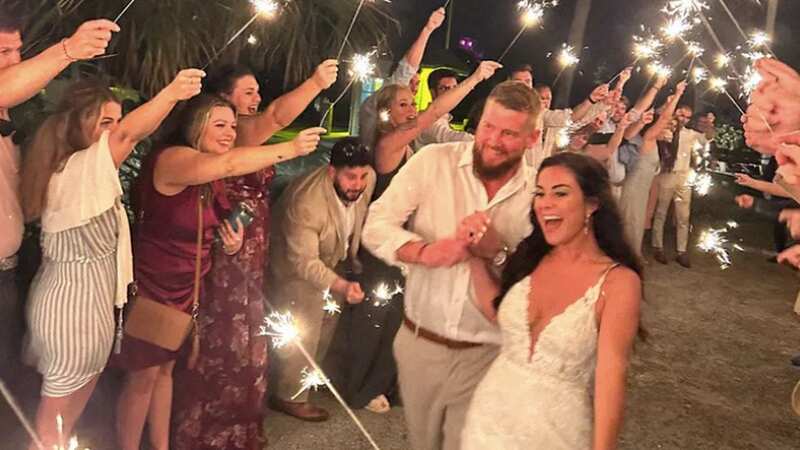 The bride and groom beam as their wedding guests wave them off (Image: GoFundMe/Folly Beach Police/MEGA)