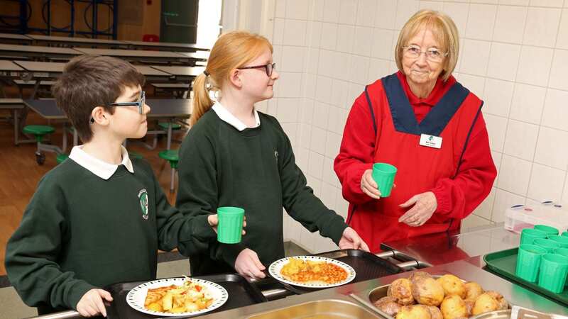 Shirley Irlam helping children in the school canteen (Image: Julian Hamilton/Daily Mirror)