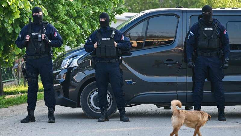 Masked policemen secure an area in the village of Dubona near the town of Mladenovac (Image: AFP via Getty Images)