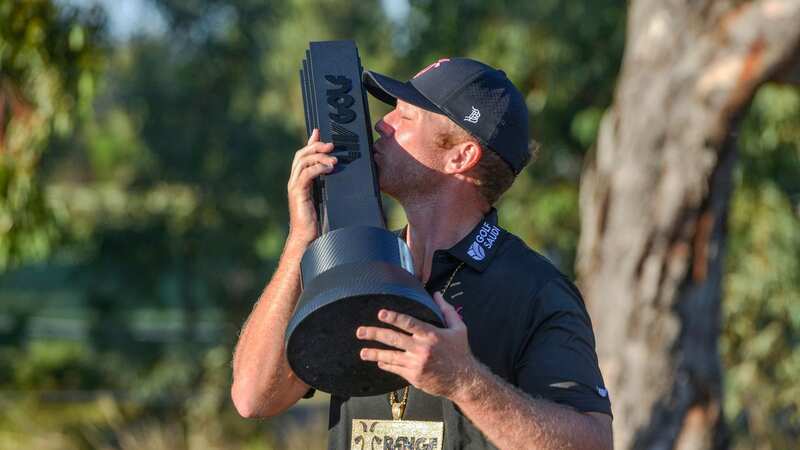 Talor Gooch of the US kisses the trophy after winning the 2023 Liv Golf tournament in Adelaide (Image: BRENTON EDWARDS/AFP via Getty Images)