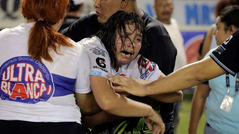 A woman is held by other fans as she sobs following the stampede at the football match in El Salvador (Image: AFP via Getty Images)