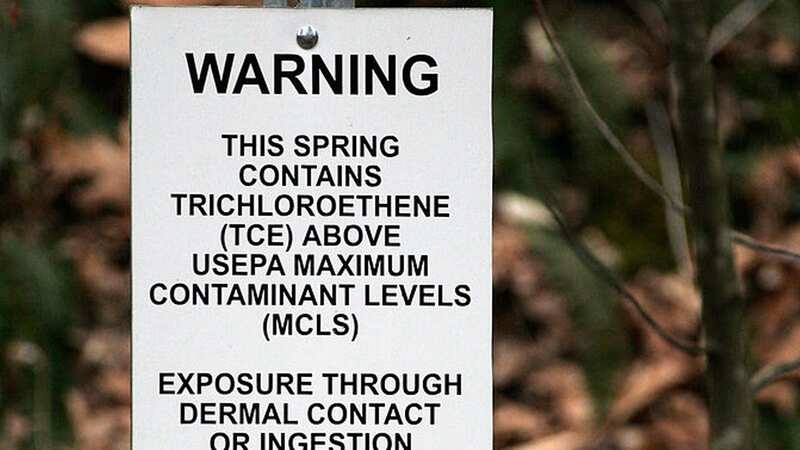 A sign warning of the dangers of elevated TCE levels in a stream - the chemical linked to an increase in Parkinson