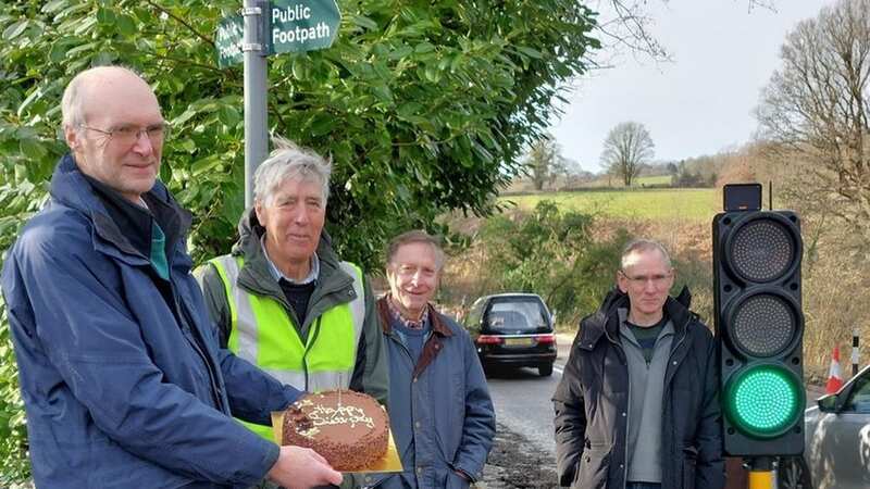 Frustrated residents marked the first anniversary of the introduction of temporary traffic lights on a major road with a birthday cake