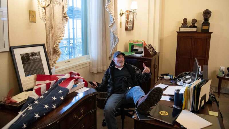 Richard Barnett, a supporter of US President Donald Trump, sits inside the office of US Speaker of the House Nancy Pelosi (Image: AFP via Getty Images)