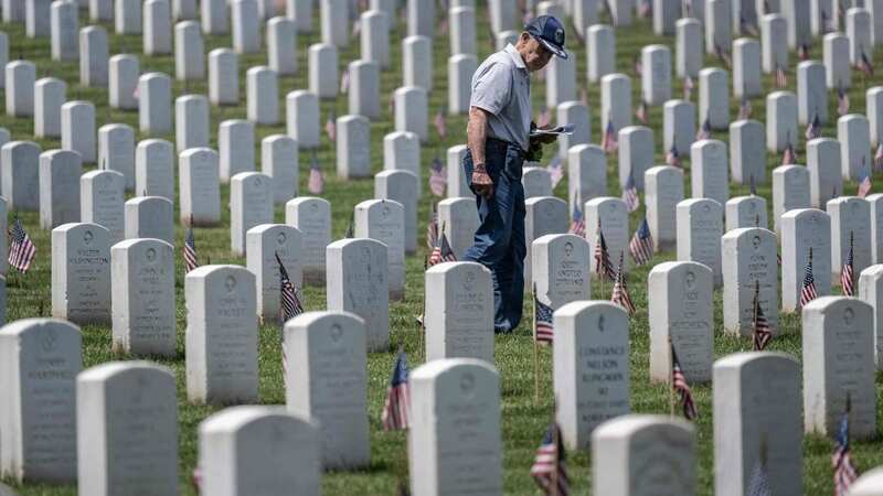 A man uses a map to find a headstone in Arlington National Cemetery before the Memorial Day weekend in Arlington, Virginia (Image: AFP via Getty Images)