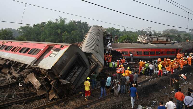 Rescue workers gather around damaged carriages in India after the crash (Image: AFP via Getty Images)