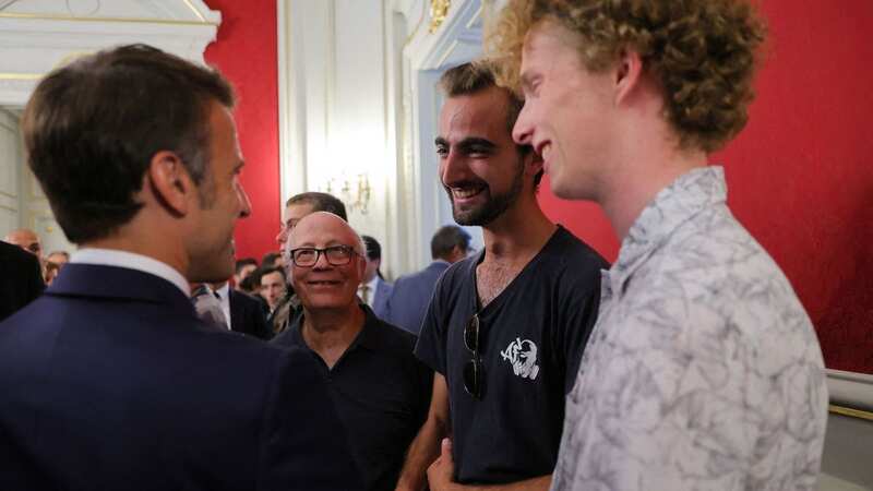 French President Emmanuel Macron (L) shakes hands Henri (2nd R), the 24-year-old known as the 