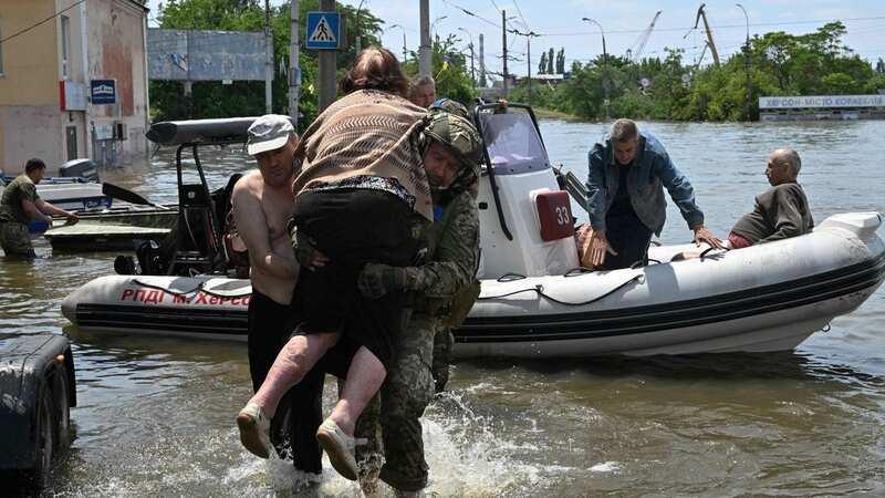 Troops help an elderly woman in Kherson (Image: AFP via Getty Images)