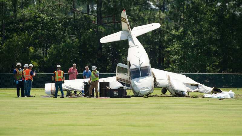 Safety workers siphon out fuel from a small plane that crashed behind the Ocean Springs Middle School (Image: AP)