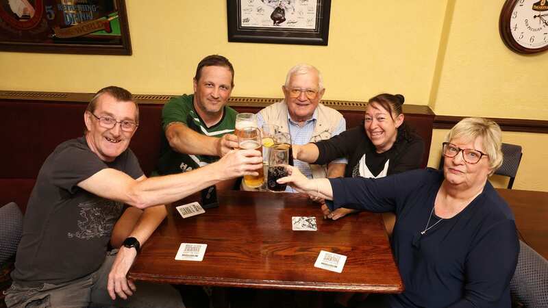 Terry, centre, and president Carol, right, clink glasses with locals (Image: Julian Hamilton/Daily Mirror)
