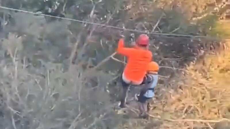 The boy and an adult standing on the zip line just moments before he fell into the lake below (Image: CEN)