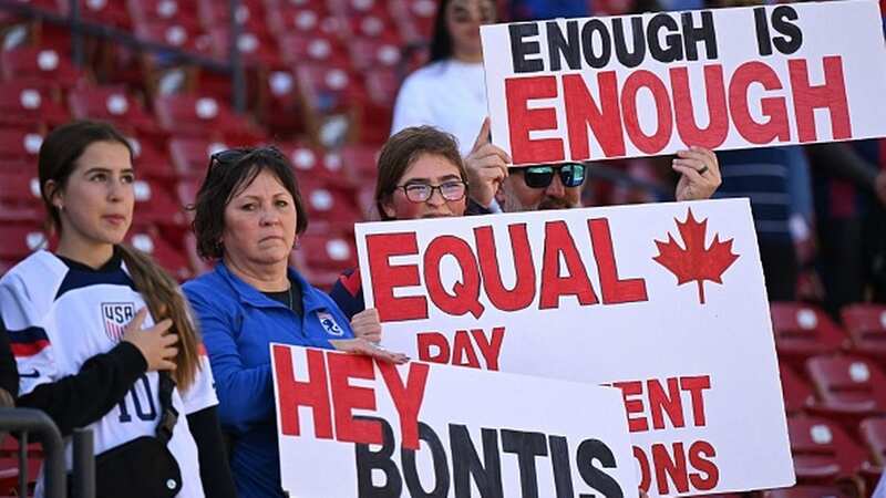 Fans hold signs in support of the Canadian womens national soccer teams protest for equal pay ahead of the 2023 SheBelieves Cup (Image: Photo by PATRICK T. FALLON/AFP via Getty Images)