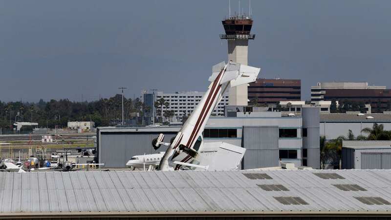 A pilot had a lucky escape after crashing his plane nose first into an airport hangar (Image: AP)
