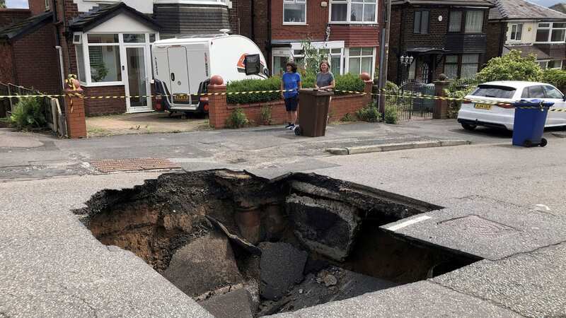 The huge hole suddenly opened up in the residential road in Prestwich (Image: Bury Times / SWNS)