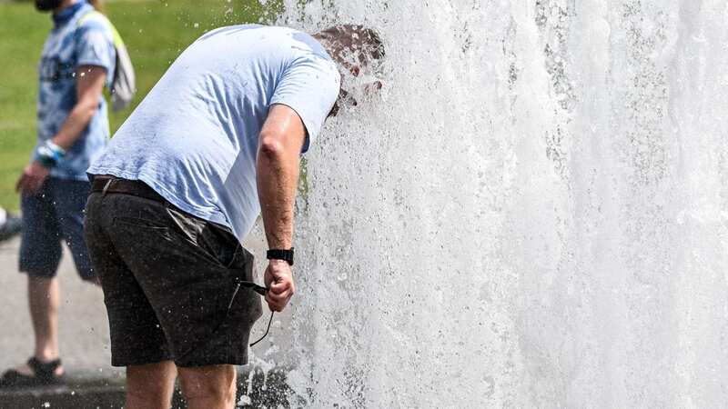 A man cools himself with water from a public fountain in central Berlin (Image: FILIP SINGER/EPA-EFE/REX/Shutterstock)