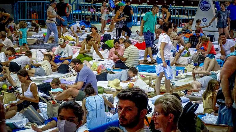 Evacuees sit inside a stadium following their evacuation (Image: AP)