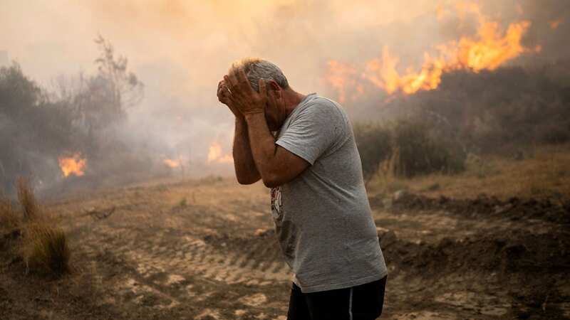 A man caught in the wildfires that burn through a village on Rhodes (Image: AFP via Getty Images)