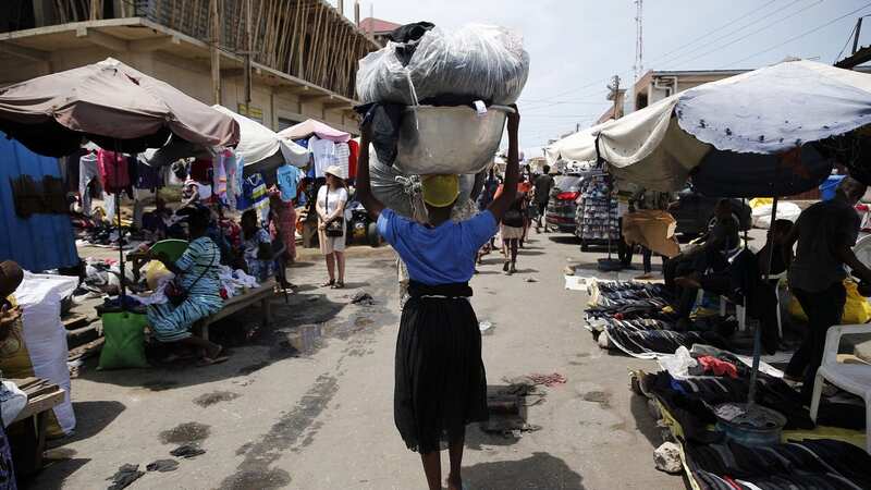 A kayayei carrying second-hand goods through Kantamanto Market in Ghana (Image: The Daily Mirror)