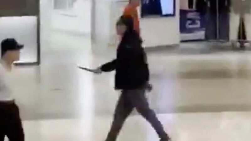 The knifeman is pictured on CCTV running through the shopping centre