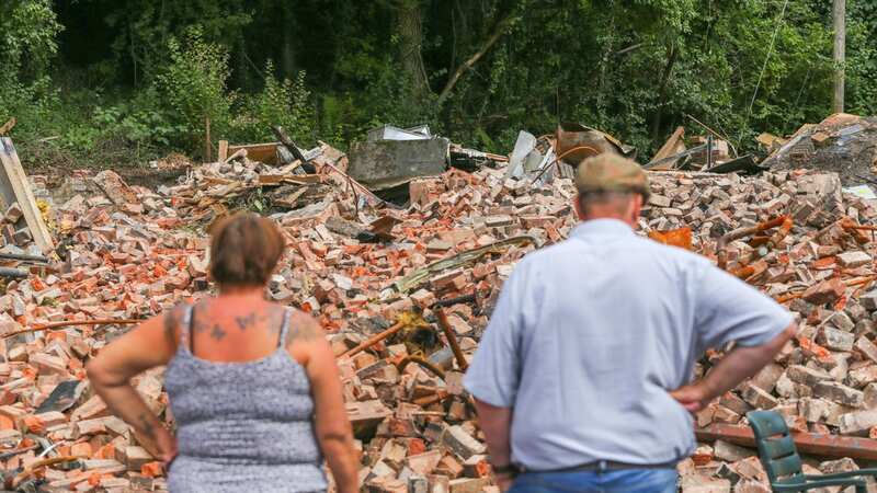 Locals look over the remains of the Crooked House pub (Image: SWNS)