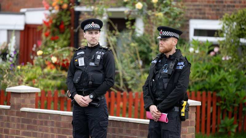Officers remain at the scene in Surrey (Image: SWNS)