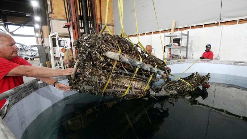 The mussel clad wreckage is treated by experts in a chemical solution (Image: AP)