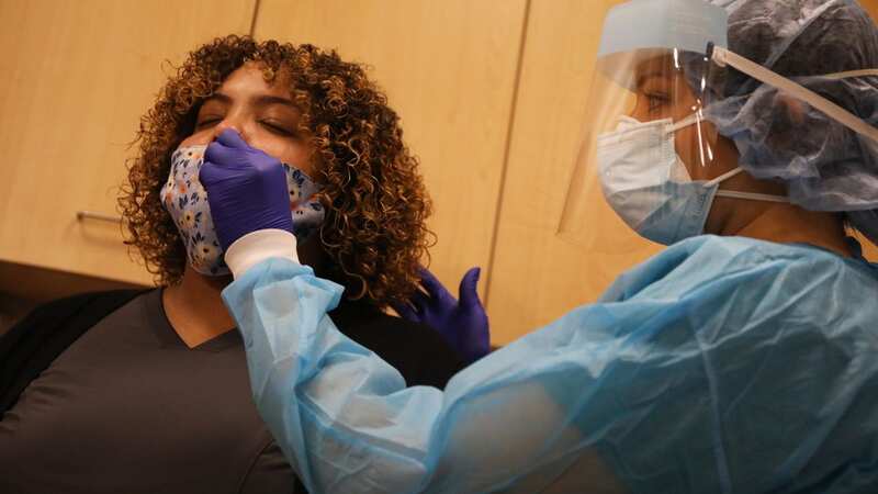 A medical worker shows the process for rapid coronavirus testing (Image: Getty Images)