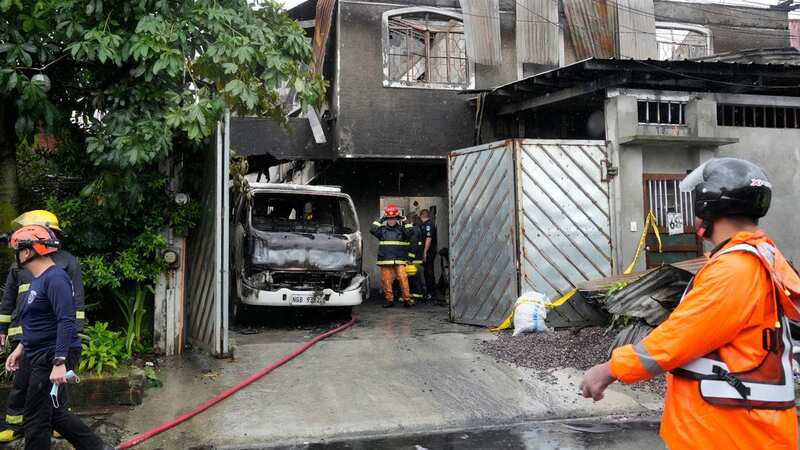 Firemen check a factory that caught fire in Quezon city, Philippines (Image: AP)